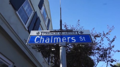 Street sign for Chalmers Street in the French Quarter, with a clear blue sky in the background.