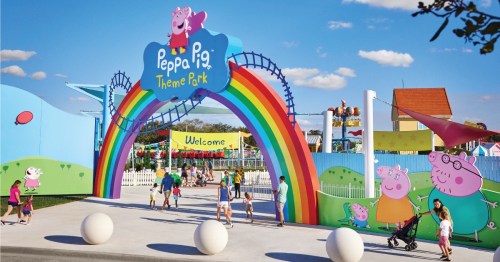 Colorful entrance to Peppa Pig Theme Park, featuring a rainbow arch and playful characters, with families enjoying the day.
