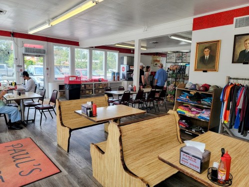 Interior of a casual diner with wooden tables, colorful decor, and customers enjoying their meals.