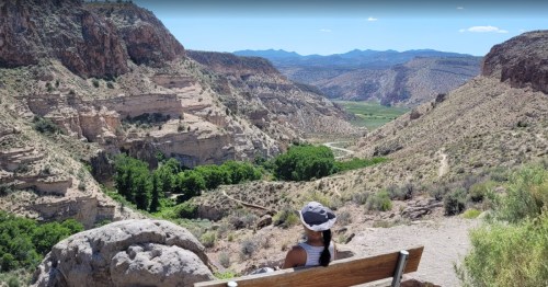 A hiker sits overlooking Rainbow Canyon at Kershaw-Ryan State Park in Nevada.
