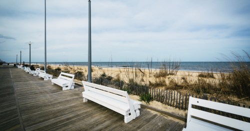 benches line the boardwalk by the beach in rehoboth beach delaware