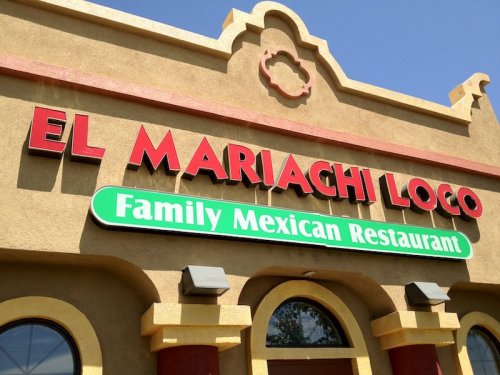 Sign for "El Mariachi Loco," a family Mexican restaurant, featuring colorful lettering on a building facade.