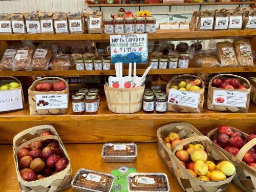 A display of various apples, jars of preserves, baked goods, and a sign for North Carolina mountain apples.