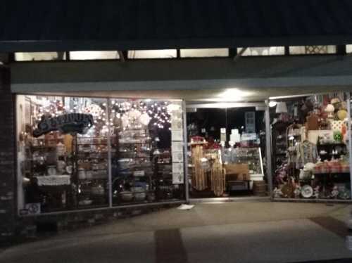 A storefront filled with various items, including decorations and collectibles, illuminated by warm lights.