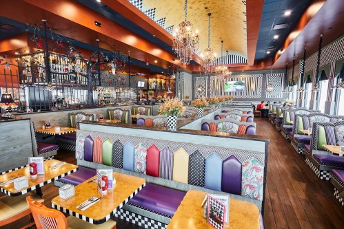 Brightly decorated restaurant interior with colorful booths, chandeliers, and a lively atmosphere.