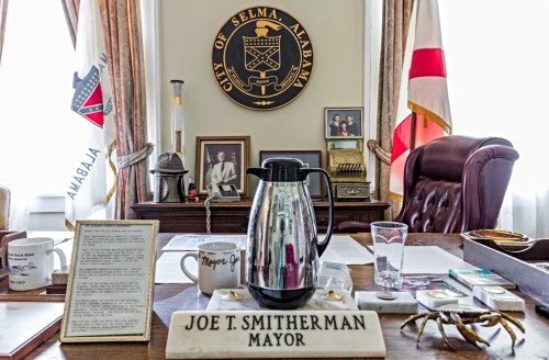 A mayor's office desk with a coffee pot, documents, and a nameplate reading "JOE T. SMITHERMAN MAYOR" in Selma, Alabama.