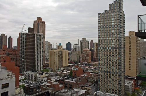 A city skyline featuring a mix of modern and older buildings under a cloudy sky.