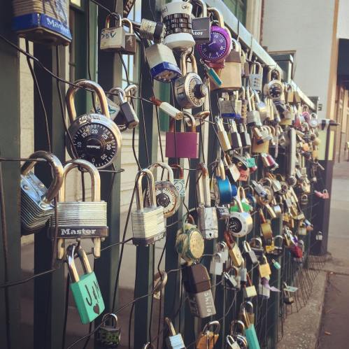 A close-up of a fence covered in various padlocks of different colors and sizes, creating a vibrant display.