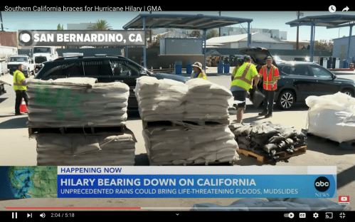 Workers in safety vests prepare sandbags in San Bernardino, CA, as they brace for Hurricane Hilary's impending impact.
