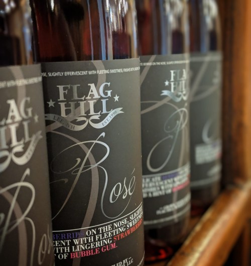 Close-up of Flag Hill Rosé wine bottles, featuring elegant labels with tasting notes and a dark background.