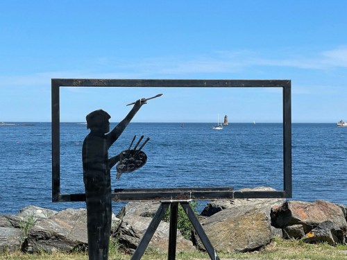 A silhouette of a painter in a frame, overlooking a calm sea with boats and a lighthouse in the distance.