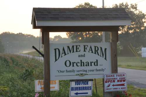 Sign for Dame Farm and Orchard, featuring "You Pick Blueberries" and "Vegetable Stand Open Now" messages.