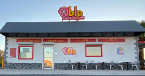 Exterior of Criss Angels Breakfast, Lunch & Pizza restaurant with a sign and outdoor seating.