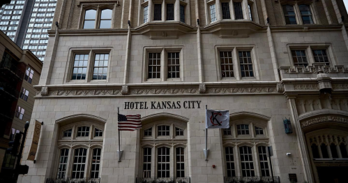 Historic Hotel Kansas City building with American flags and elegant architectural details.
