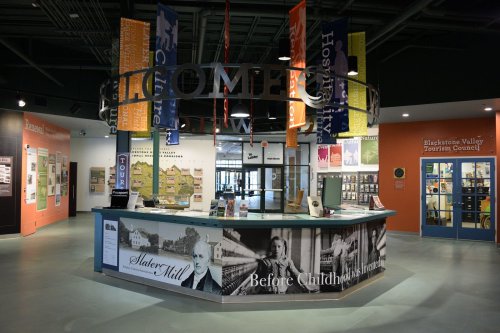 A welcoming visitor center with colorful banners, informational displays, and a reception desk in a modern space.