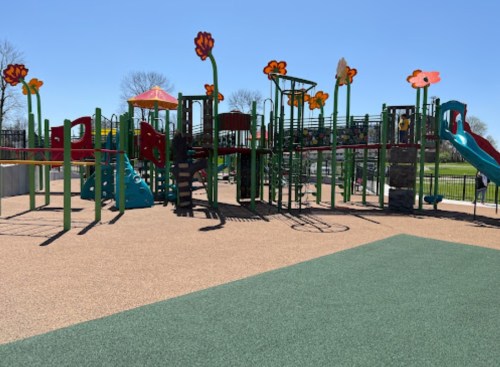 Colorful playground with flower-themed structures, slides, and climbing areas on a sunny day.