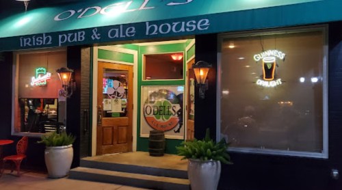 Exterior of O'Dell's Irish Pub & Ale House, featuring a green awning, lanterns, and a Guinness sign.