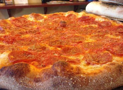 Close-up of a pepperoni pizza with a golden crust and vibrant red sauce, fresh out of the oven.