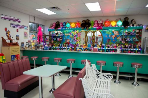 A colorful diner interior with plush toys, a vibrant counter, and retro-style seating.