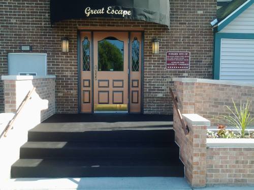 Entrance of a building named "Great Escape," featuring double doors and brick steps leading up to it.