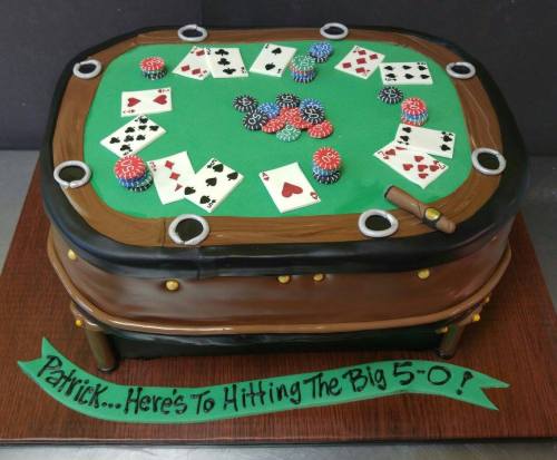A cake designed like a poker table, featuring playing cards, poker chips, and a message celebrating a 50th birthday.