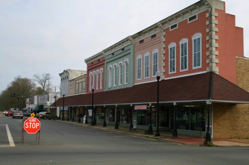 A quiet street scene featuring historic buildings with colorful facades and a stop sign in the foreground.