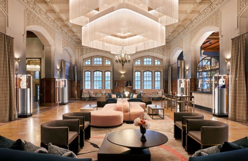 Elegant hotel lobby featuring modern seating, large windows, and stylish lighting fixtures.