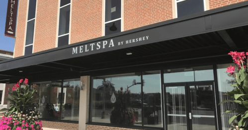 Exterior view of MELTSPA by Hershey, featuring a modern entrance and decorative plants.