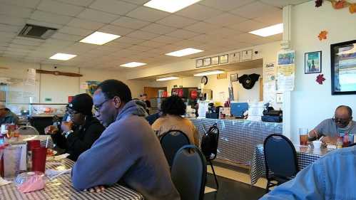 A cozy diner scene with patrons enjoying meals at checkered tables, a counter in the background with food and drinks.