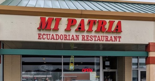 Sign for "Mi Patria" Ecuadorian Restaurant, featuring red letters and an open sign in the window.