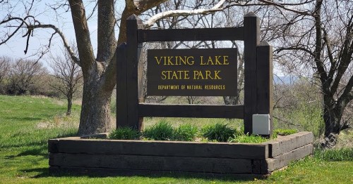 Sign for Viking Lake State Park, surrounded by grass and trees, indicating the Department of Natural Resources.
