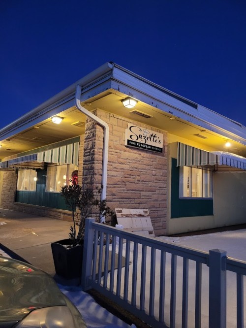 Exterior of a restaurant named "Svetta's" at dusk, featuring a stone facade and illuminated sign.