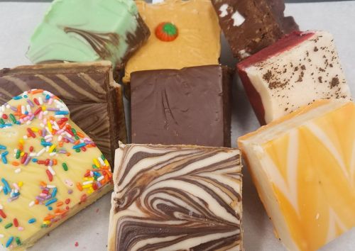 A colorful assortment of fudge pieces with various flavors and toppings, arranged on a white surface.