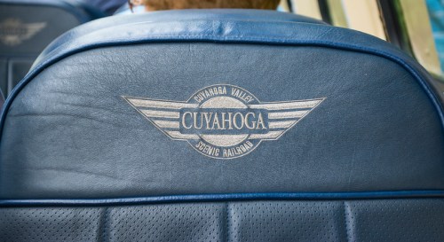 Close-up of a blue train seat back featuring the "Cuyahoga Valley Scenic Railroad" logo.