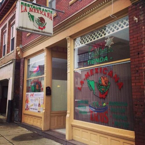 Exterior of "La Mexicana" restaurant, featuring colorful signage and a storefront with large windows.