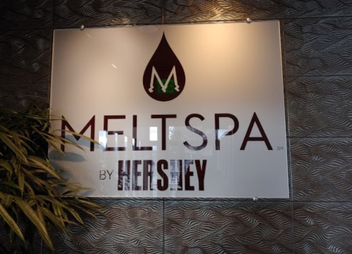 Sign for "MeltSpa by Hershey" featuring a stylized logo and a textured background.