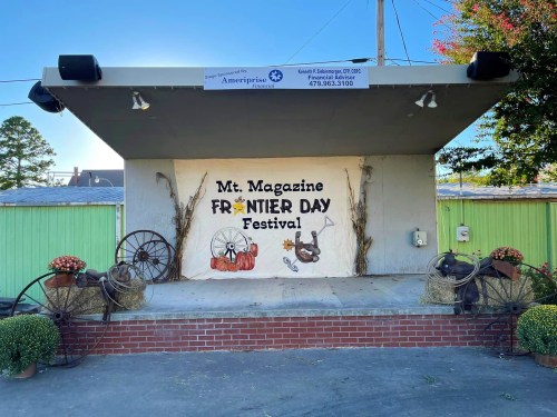 Stage decorated for the Mt. Magazine Frontier Day Festival, featuring hay bales, pumpkins, and rustic decor.