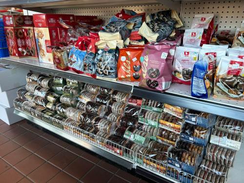A display shelf filled with various packaged snacks, including donuts and cookies, in a store setting.