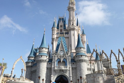 A majestic castle with blue spires and intricate architecture under a clear blue sky.