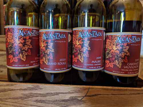 A collection of wine bottles from Alcantara Vineyards, featuring labels for Syrah, Grand Rouge, Malbec, and Cabernet Sauvignon.