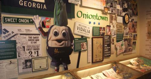 A display featuring a mascot and various historical items about Vidalia, Georgia, and its sweet onions.