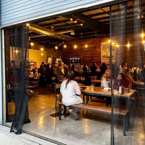 A cozy café scene with people socializing inside, warm lighting, and a welcoming atmosphere.