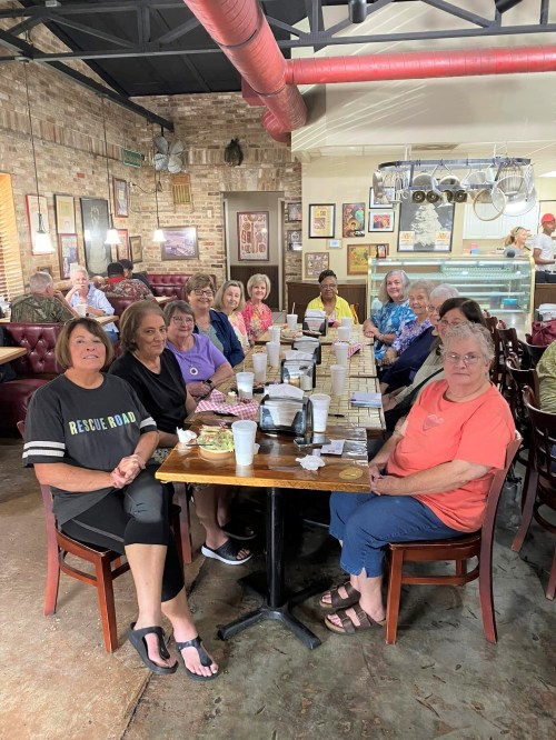 A group of women sitting at a table in a cozy restaurant, enjoying food and conversation.
