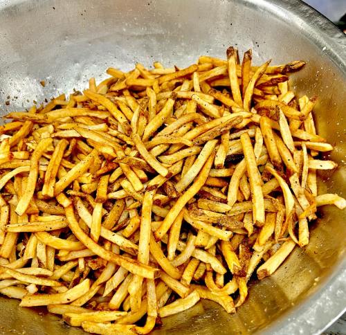 A large bowl filled with golden-brown, crispy French fries.