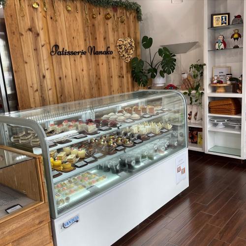 A display case filled with various pastries and desserts in a cozy patisserie setting.