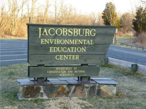 Sign for Jacobsburg Environmental Education Center, featuring wooden design and natural surroundings.
