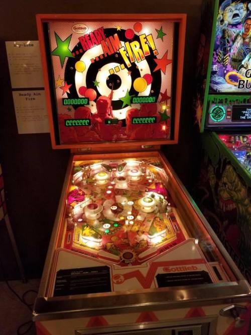 A colorful vintage pinball machine with bright lights and retro graphics, featuring a "Fire!" theme.