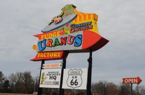 Colorful sign for "Uranus Fudge Factory" with additional information about nearby attractions and stores.