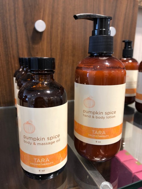 Two bottles of pumpkin spice body products: a 4 oz body and massage oil and an 8 oz hand and body lotion.