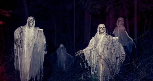 Four ghostly figures with skeletal faces and tattered white garments stand in a dark forest.